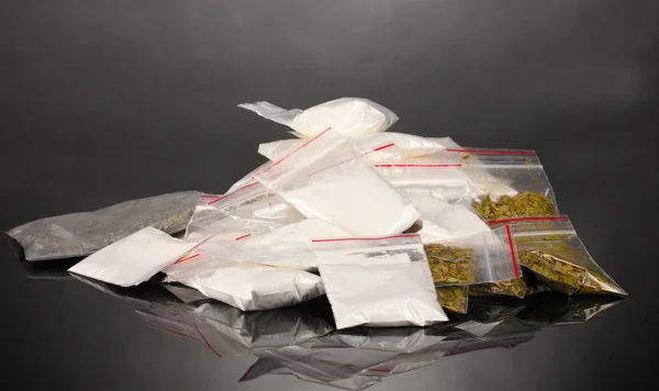 Кокаин и марихуана в упаковках на сером фоне — стоковое фото
