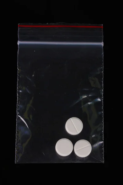 Drogen im Paket auf schwarzem Hintergrund — Stockfoto