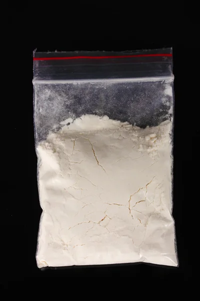 Kokain in Packung auf schwarzem Hintergrund — Stockfoto