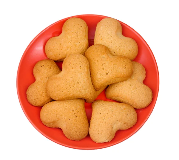 Galletas en forma de corazón en platillo rojo aislado en blanco —  Fotos de Stock