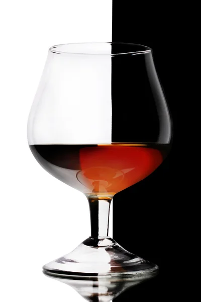 Glas Cognac auf weiß-schwarzem Hintergrund — Stockfoto