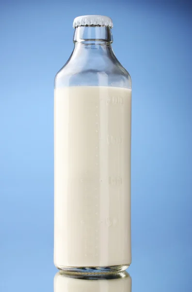 파란색 배경에 우유 병 — 스톡 사진