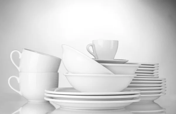 Cuencos vacíos, platos y tazas sobre fondo gris —  Fotos de Stock