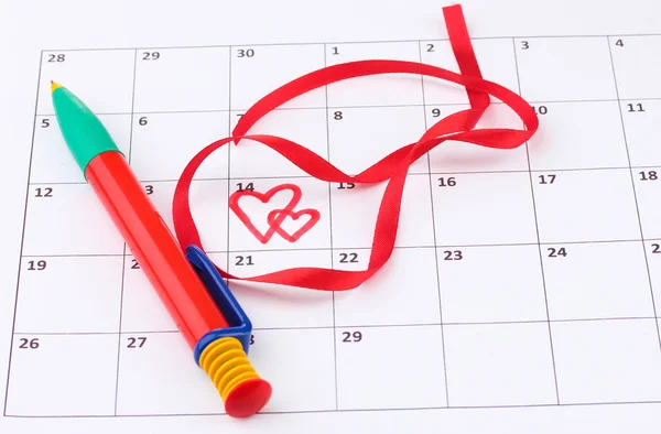 Календарь с сердцами, ручкой и лентой на День Святого Валентина — стоковое фото