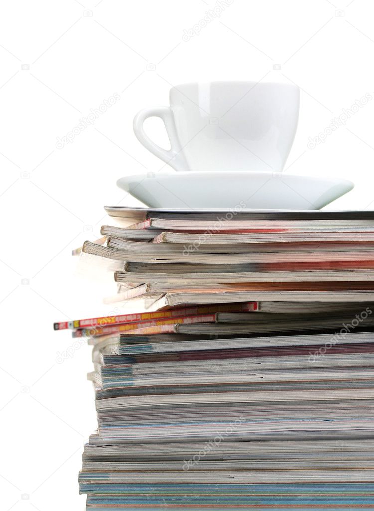 Stack of magazines and cup isolated on white