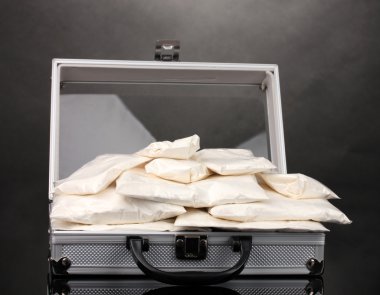 Cocaine in a suitcase on grey background clipart