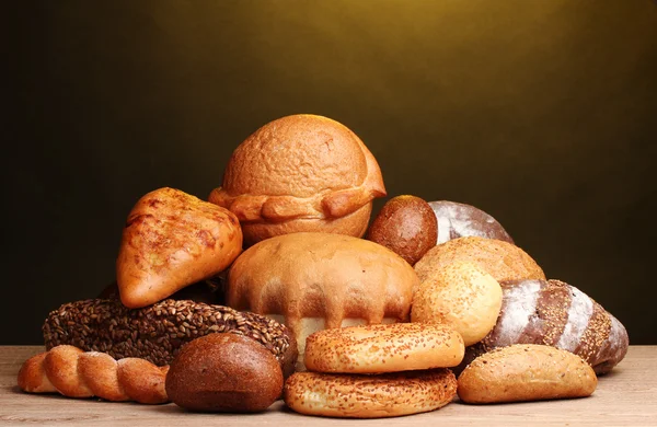Leckeres Brot auf Holztisch auf braunem Hintergrund — Stockfoto