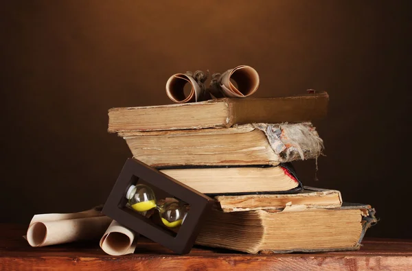 Pile of old books and scroll on brown — Stock Photo, Image
