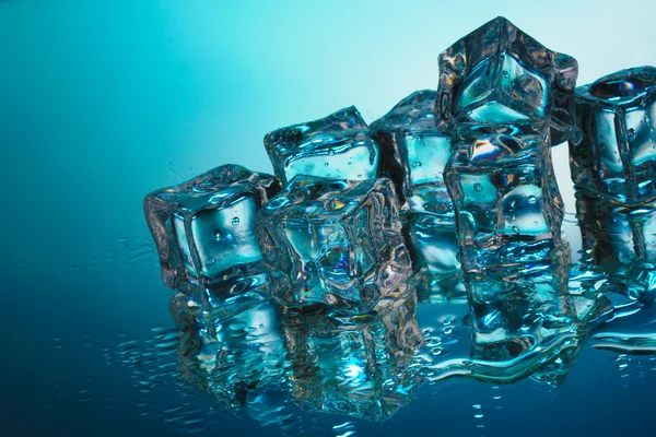 Derretimiento de cubitos de hielo sobre fondo azul —  Fotos de Stock