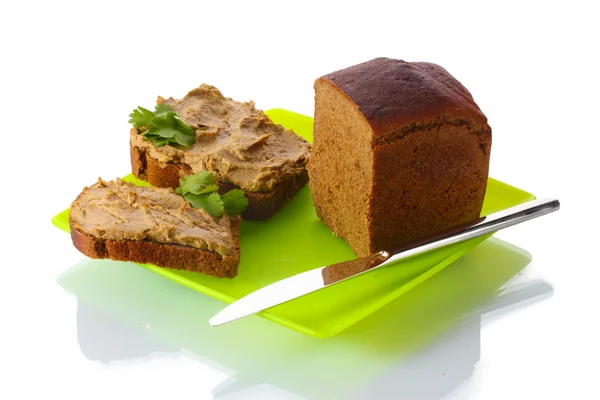 Свежий паштет на хлеб на зеленой тарелке изолирован на белом — стоковое фото