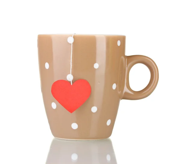 Brown cup and tea bag with red heart-shaped label isolated on white — Stock Photo, Image