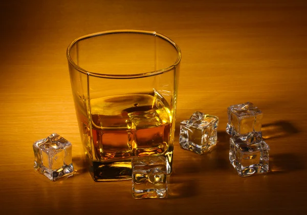 Bicchiere di whisky scozzese e ghiaccio sul tavolo di legno — Foto Stock