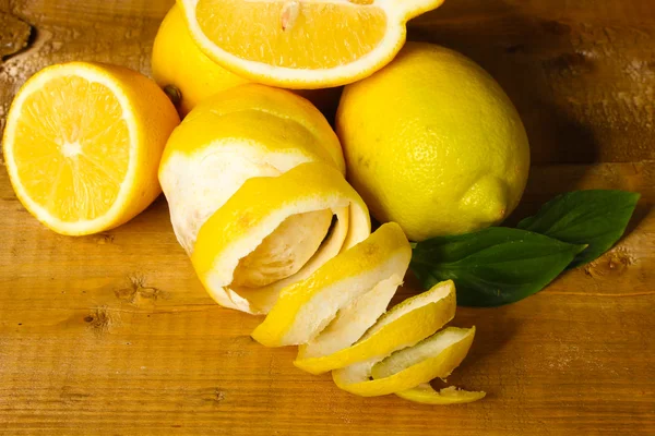 Limões maduros com folhas na mesa de madeira — Fotografia de Stock