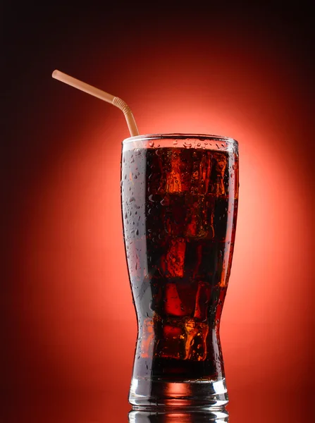 Glass of cola with ice on red background — Stock Photo, Image