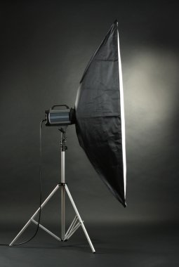 Studio flash with soft-box on black studio background clipart