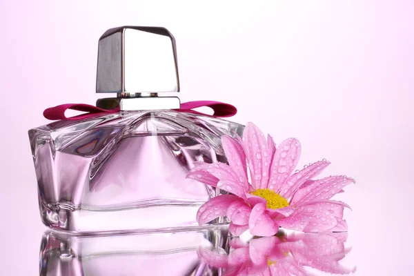 Gyönyörű üveg és a rózsaszín háttér virág Női parfüm — Stock Fotó