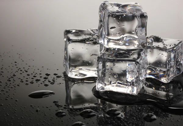 Scioglimento cubetti di ghiaccio su sfondo grigio — Foto Stock