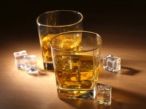 Två glas av skotsk whisky och is på träbord — Stockfoto