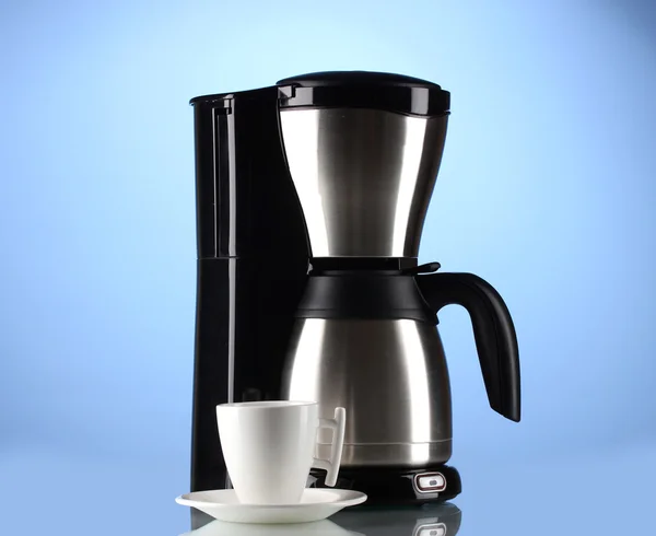 Macchina per il caffè con tazza bianca su sfondo blu — Foto Stock