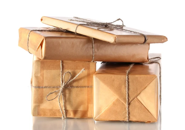 Molti pacchi avvolti in carta marrone legati con spago isolato su bianco — Foto Stock