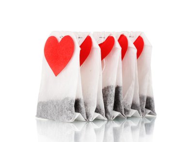 Tea bags with blank heart-shaped labels isolated on white clipart