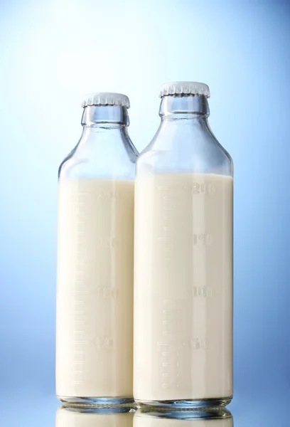 Garrafas de leite no fundo azul — Fotografia de Stock