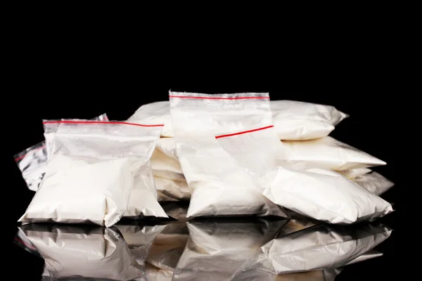 Cocaina in pacchetti su sfondo nero — Foto Stock