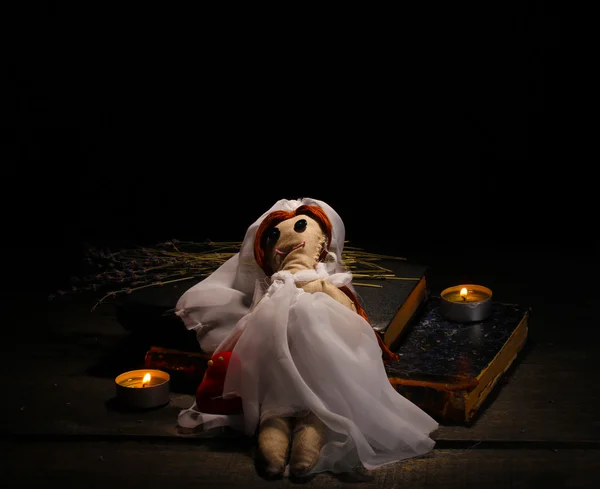 Voodoo boneca menina-noiva em uma mesa de madeira à luz das velas — Fotografia de Stock