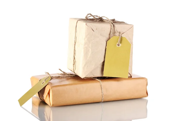 Dos paquetes envueltos en papel marrón atado con hilo y con etiquetas en blanco es — Foto de Stock