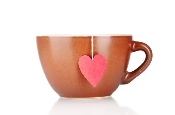 Tazza marrone e bustina di tè con etichetta rossa a forma di cuore isolata su bianco — Foto Stock