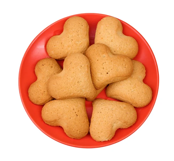 Biscotti a forma di cuore su piattino rosso isolato su bianco — Foto Stock