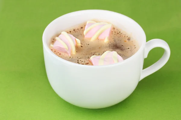 Tasse Cappucino mit Marshmallows auf grünem Hintergrund — Stockfoto