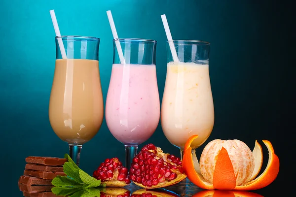 Milk shakes with fruits and chocolate on blue background — Stock Photo, Image