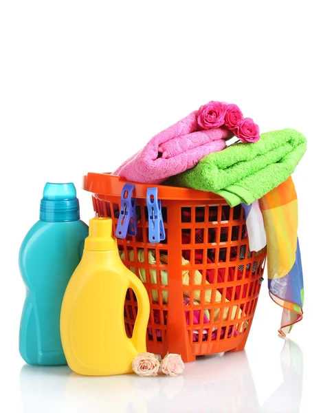 Ropa con detergente en cesta de plástico naranja aislada en blanco — Foto de Stock