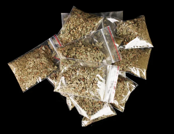Marihuana in Paketen auf schwarzem Hintergrund — Stockfoto