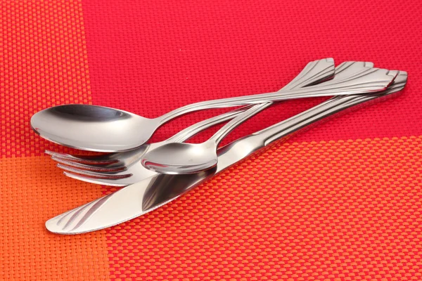 Gabel, Löffel und Messer auf rotem Tischtuch — Stockfoto