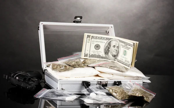 Kokainu a marihuany s pistolí v kufru na šedém pozadí — Stock fotografie
