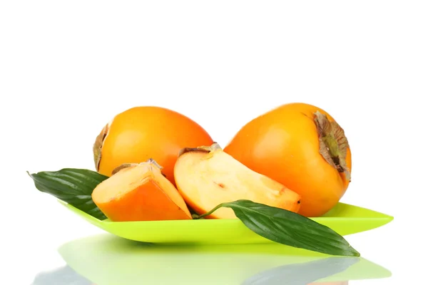 Two appetizing persimmons on green plate isolated on white — Stock Photo, Image