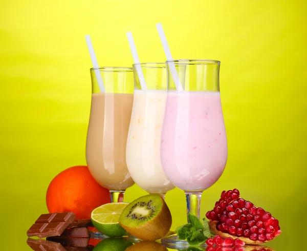 Milk shakes with fruits and chocolate on green background — Stock Photo, Image