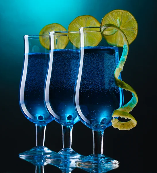 Modrý koktejl v brýlích vápnem na modrém pozadí — Stock fotografie