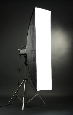 Studio flash with soft-box on black studio background clipart