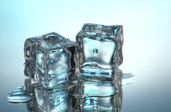 Smältande is kuber på blå bakgrund — Stockfoto