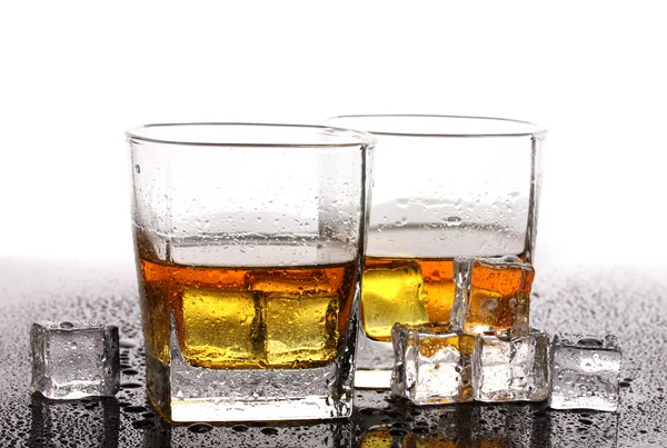 Zwei Gläser Scotch Whiskey und Eis auf dem Tisch isoliert auf weiß — Stockfoto