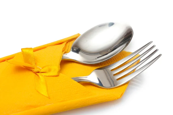 フォークとスプーンを白で隔離される弓と黄色の布 — ストック写真