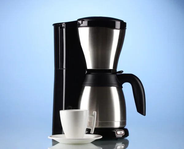 Macchina per il caffè con tazza bianca su sfondo blu — Foto Stock
