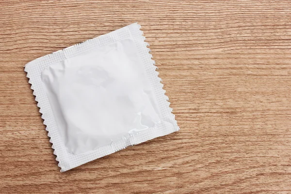 Один презерватив на дерев'яному тлі — стокове фото