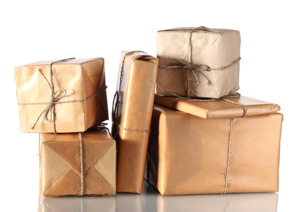 Muchos paquetes envueltos en papel marrón atado con cordel aislado en blanco —  Fotos de Stock