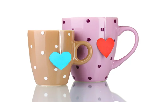 Two cups and tea bags with red and blue heart-shaped label isolated on whit — Stock Photo, Image