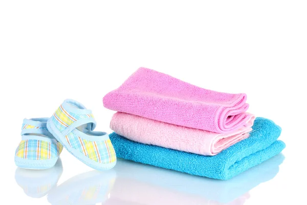 Botinhas de bebê azul e três toalhas coloridas isoladas em branco — Fotografia de Stock
