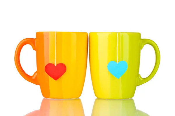 Duas xícaras e sacos de chá com rótulo vermelho e azul em forma de coração isolado no whit — Fotografia de Stock